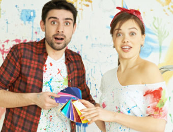 a couple standing in a room choosing colours for decorating the room