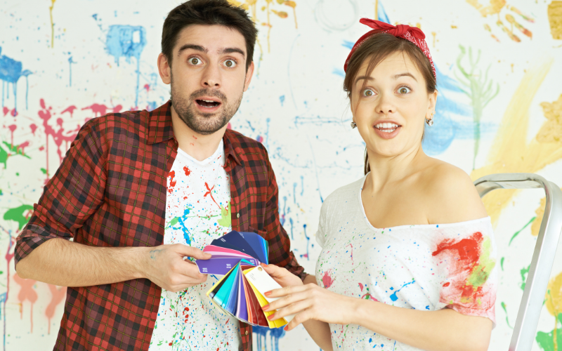 a couple standing in a room choosing colours for decorating the room